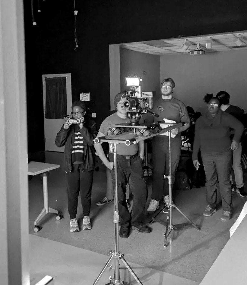 The Reach Studio crew operating the camera on a studio set, black and white