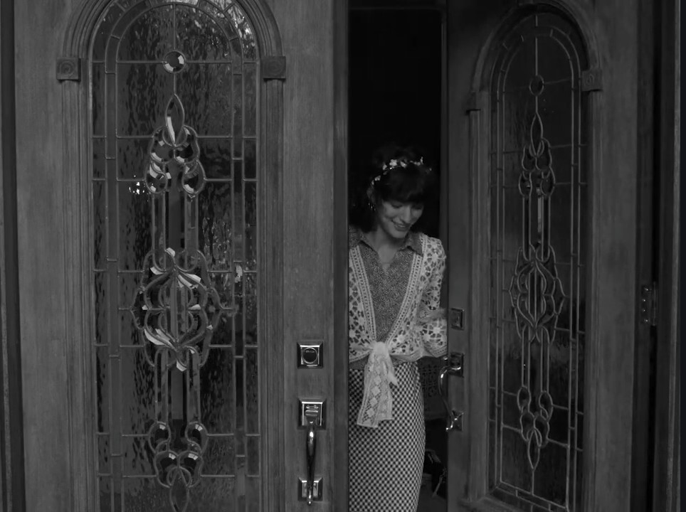 Production still from Pass The Salt — a hand drawing a knife at a doorway, black and white