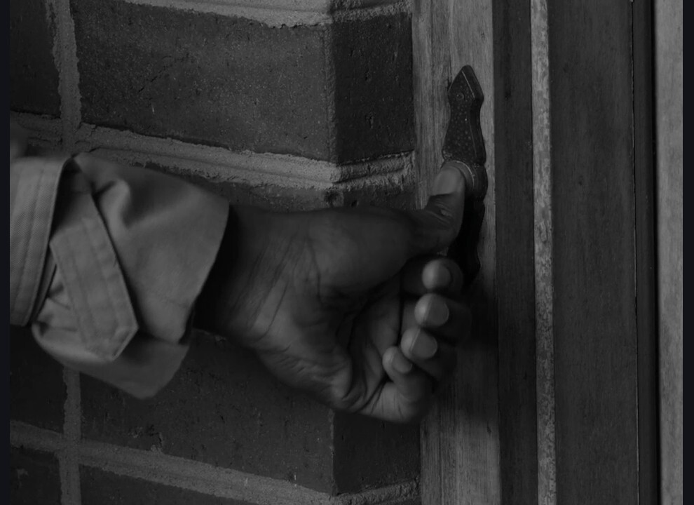 Production still from Pass The Salt — a woman opening an ornate front door